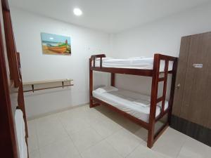 コベニャスにあるCabaña la Isla-Coveñasの二段ベッド2台、冷蔵庫が備わる客室です。