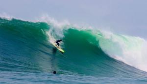 a man riding a wave on a surfboard in the ocean at Almar Punta Hermosa in Punta Hermosa
