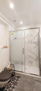 una ducha con puerta de cristal en una habitación en Cosy Studio aux Batignolles - Proche Montmartre, en París