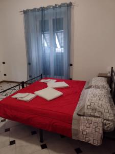 een slaapkamer met een bed met een rode deken en een raam bij Villa il sole in Genua