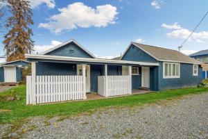a blue house with a white fence at Charming Midtown Bungalow Slumber Village 2 in Anchorage