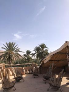 un patio con sillas y palmeras en el desierto en GITE LA GROTTE VALLEE 