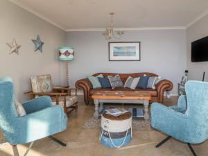 a living room with two blue chairs and a couch at Looe Island View in Torpoint