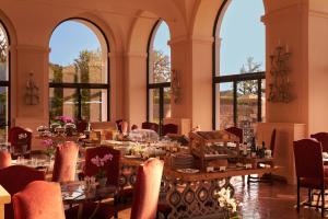 a dining room with tables and chairs and windows at La Posta Vecchia Hotel in Ladispoli