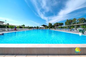 a large swimming pool with blue water at Village Due Elle in Schiavonea