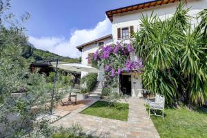 una casa con un jardín con flores púrpuras en Il Nido dei Gufi Bed and Breakfast, en Toscolano Maderno