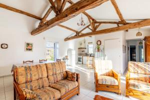 een woonkamer met een bank en 2 stoelen bij La clé des champs in Saint-Julien-des-Landes