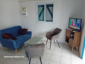 ein Wohnzimmer mit einem blauen Sofa und einem Tisch in der Unterkunft gîte La Cannaie in Port-Louis