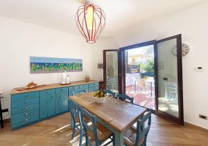 a kitchen with a wooden table and blue cabinets at Solemar Sicilia - Villa Mariù in Palermo