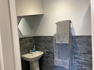 a bathroom with a sink and a toilet and a towel at Ashburnam Guest House in Hornsea