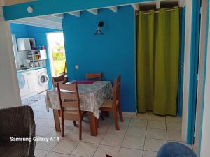 a dining room with a table and a green curtain at gîte La Cannaie in Port-Louis