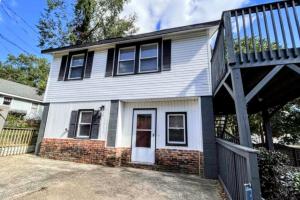 Casa blanca con porche y balcón en Stylish Retreat - 4 Min Downtown, en Greenville