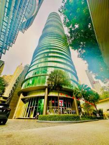 a tall building with a tree in front of it at vortex suites KLCC area Dormeo in Kuala Lumpur