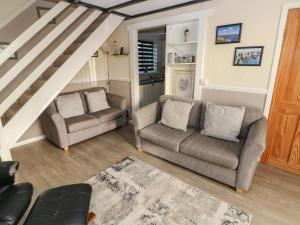 uma sala de estar com dois sofás e uma escada em The Smithy em Tenby