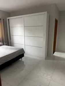 a bedroom with a bed and a large white closet at Casa Parque Aquático in Andradina