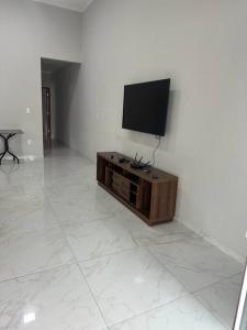 TV de pantalla plana en la parte superior de una pared blanca en Casa Parque Aquático, en Andradina