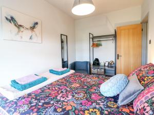 a bedroom with a bed with a colorful bedspread at 3 Sunnyside Terrace in Matlock