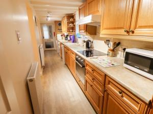 a kitchen with wooden cabinets and a counter top at 22 Beckside in Sudbrooke