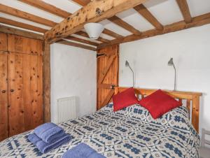 a bedroom with a bed with red and blue pillows at Pant y Crintach in Amlwch