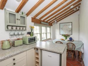 a kitchen with a counter with a microwave and a table at Pant y Crintach in Amlwch