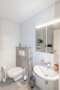 ein weißes Bad mit einem WC und einem Waschbecken in der Unterkunft Ferienwohnung "Kapellmeister" mit Klimaanlage in allen 4 Schlafbereichen, großes Wohnzimmer mit Smart TV und Big Sofa in Magdeburg