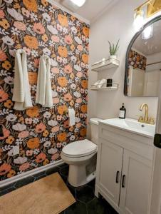 a bathroom with a toilet and a floral wallpaper at Bohemian Tiny Home - Walk to Starbucks in Taylors
