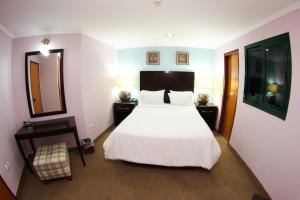 a bedroom with a white bed and a mirror at Santa Fe Inn Hotel in Punto Fijo +20 photos