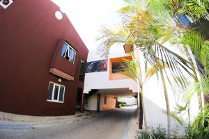 a building with a palm tree next to a street at Santa Fe Inn Hotel in Punto Fijo