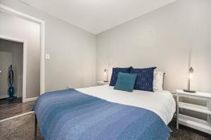 a bedroom with a large bed with blue pillows at The Downtown Delight - New Corporate Apt Downtown in Grand Rapids