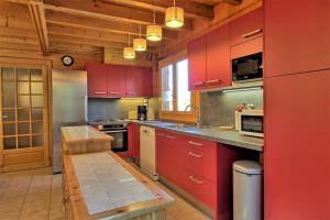 a kitchen with red cabinets and a counter top at CASA-Forêt Blanche splendid chalet 13p in Risoul