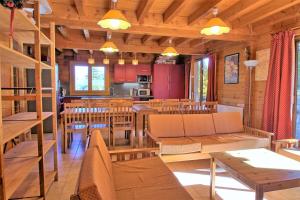 a dining room and kitchen in a log cabin at CASA-Forêt Blanche splendid chalet 13p in Risoul