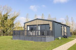 a modular home with a deck on a lawn at Keld Spring Lodge Retreat in Kirkbymoorside
