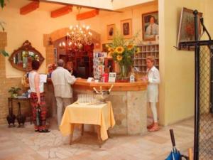 a group of people standing at a bar in a restaurant at Landhotel Gustav in Beelitz Heilstätten +12 photos