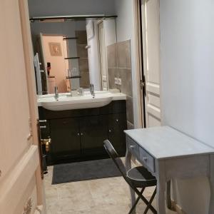 baño con lavabo y escritorio con silla en Domaine Christanna, en Lisle-sur-Tarn