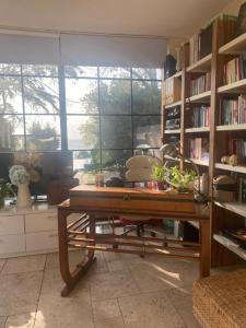 a room with a wooden table and bookshelves at PİA MARE OTEL in Gündüzlü