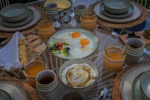 - une table avec des assiettes de nourriture pour le petit-déjeuner et des verres de jus d'orange dans l'établissement Maison Kenoosha, à Marrakech