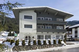 a large white building with snow on the ground at Appartementhaus Renate Unterer in Kelchsau