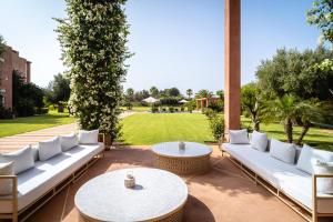 un patio con sofás blancos y una mesa en Maison Kenoosha, en Marrakech