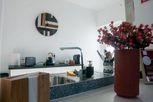 - une cuisine avec un évier et un vase de fleurs dans l'établissement InTune Peniche Property, à Peniche