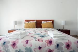 una camera da letto con un letto con due asciugamani e due lampade di InTune Peniche Property a Peniche