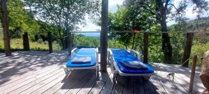 un porche con 2 camas en una terraza de madera en Bell-tenten Quinta Pomar Do Pontido, en Cabeceiras de Basto