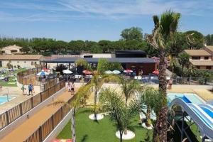 un complejo con palmeras y piscina en Maison de vacances plein pied tout confort 200m plage, en Portiragnes