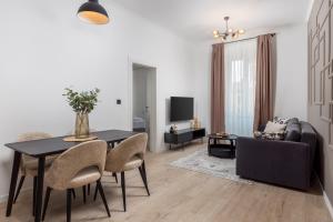 a living room with a table and a couch at Molo Longo - Downtown Apartments in Rijeka