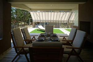 a dining room table with chairs and a tableasteryasteryasteryasteryasteryasteryastery at Avra Vip Villa in Paralía Avdhíron