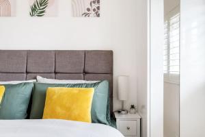 a bed with green and yellow pillows in a bedroom at Stylish Contemporary 1 Bed Flat Near London Bridge in London