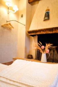 a room with a bed and a vase with flowers in it at 1870 Bed & Breakfast in Arpino