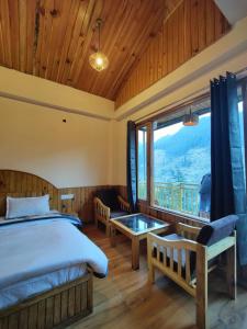 1 dormitorio con cama y ventana grande en The Woodpecker Inn Jibhi, en Jibhi