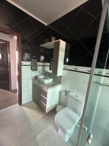 a bathroom with a toilet and a sink at Casa de Praia in Imbituba +10 photos