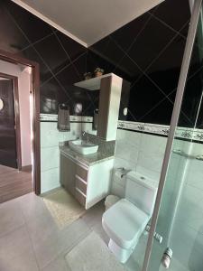 a bathroom with a toilet and a sink at Casa de Praia in Imbituba