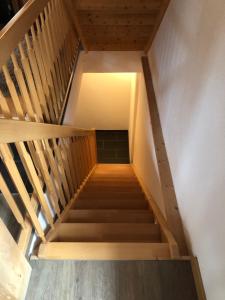 a wooden staircase with a light at the top at Hop in Nest Cozy B&B in Wengen in Wengen